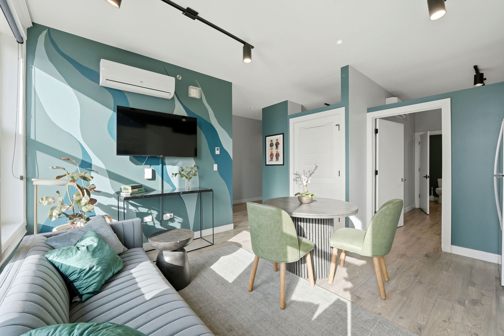 Top-floor three-bedroom suite living area with a teal and blue wave mural wall